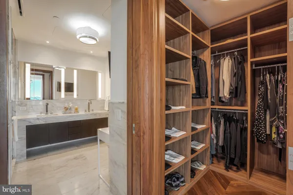 a view of walk in closet with clothes and shoes