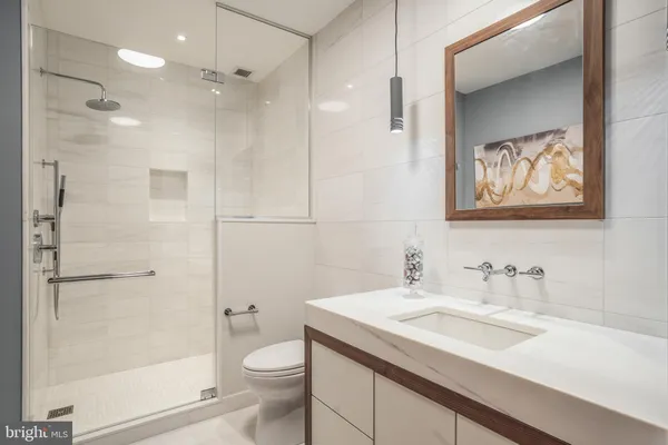 a bathroom with a sink a toilet and shower