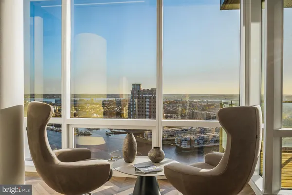 a living room with furniture a lamp and a floor to ceiling window