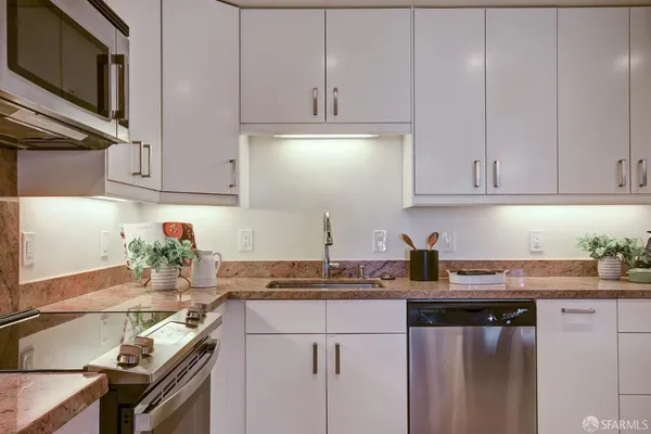 a kitchen with granite countertop kitchen island stainless steel appliances a table and chairs in it
