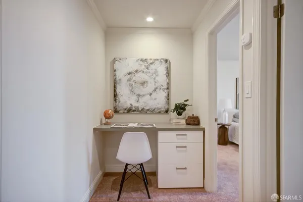 a bedroom with a bed and a lamp on dresser