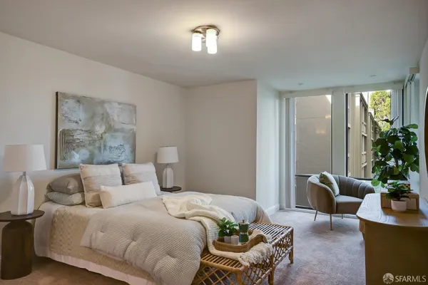 a bedroom with a large bed and a chandelier