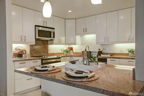 a kitchen with white cabinets stainless steel appliances and sink