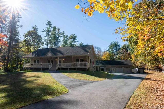 a view of a house with a yard and large tree