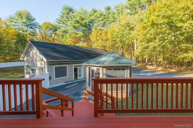 a view of a house with wooden deck and furniture