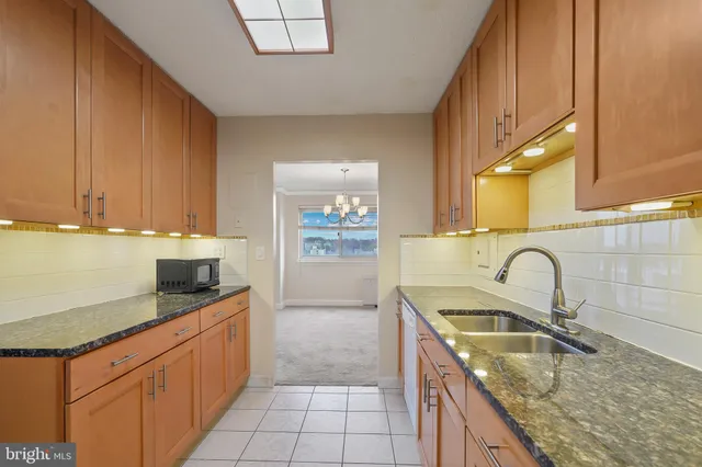 a kitchen with granite countertop wood cabinets and white appliances