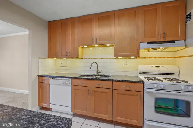 a view of kitchen with kitchen island stainless steel appliances refrigerator stove microwave and cabinets