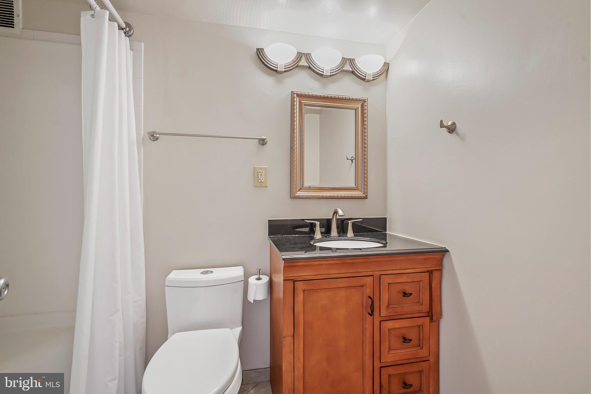 1225 Martha Custis Drive, Unit 1119 Alexandria, VA 22302 - Photo 25 of 36 a bathroom with a toilet a sink and mirror