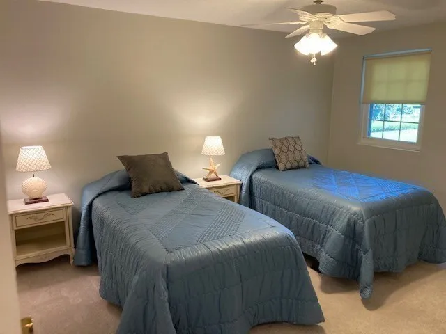 a bedroom with two beds and a chandelier
