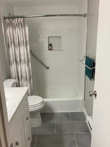 a bathroom with a shower a toilet and a sink
