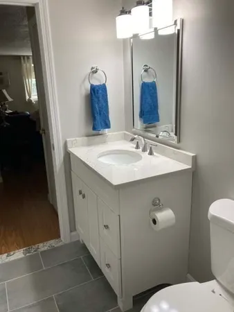 a bathroom with a sink and mirror with toilet