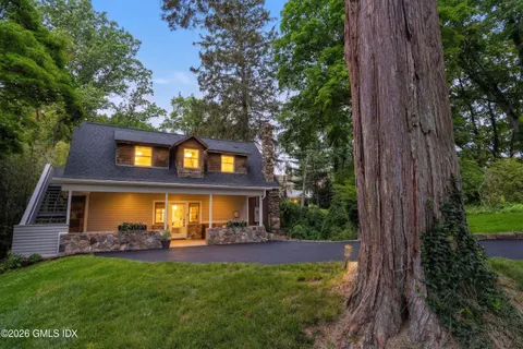 a view of house with backyard outdoor seating and green space