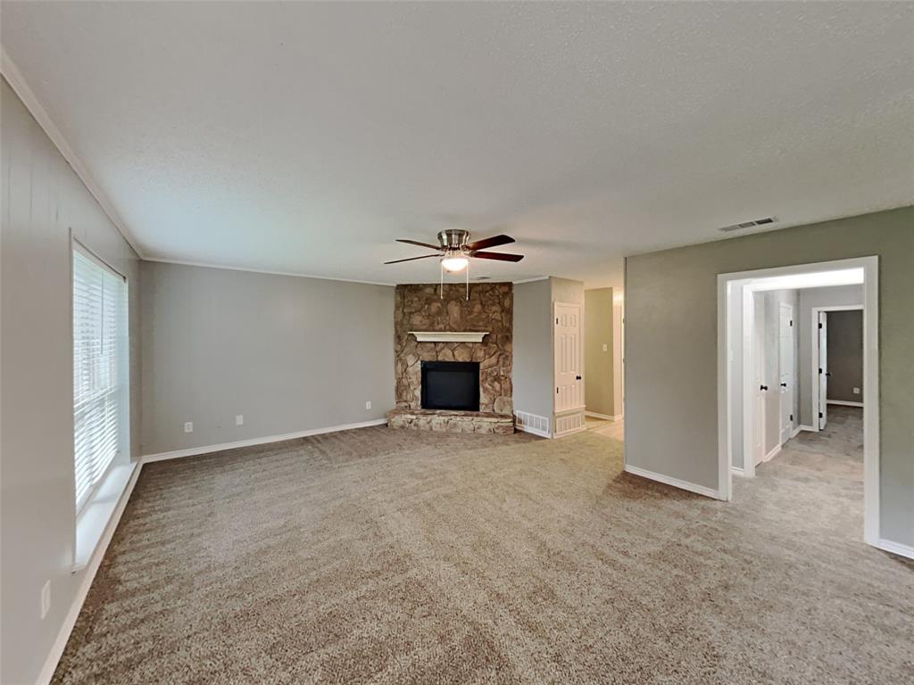 702 Redbud Drive Forney, TX 75126 - Photo 7 of 16 an empty room with fireplace and chandelier