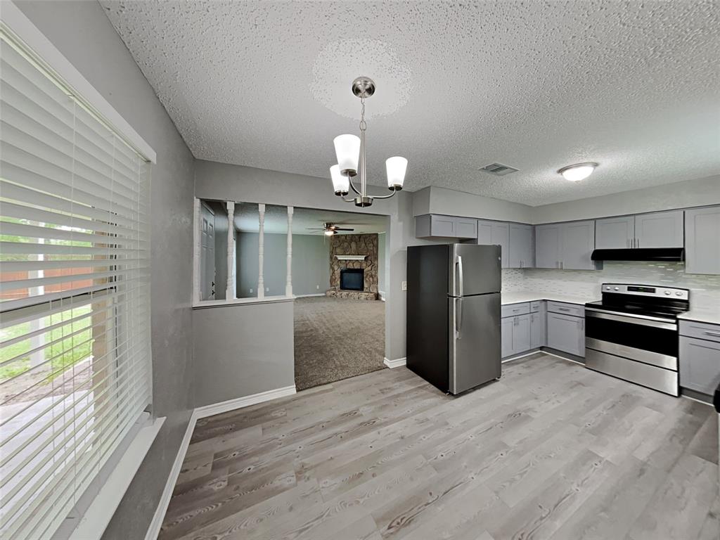 702 Redbud Drive Forney, TX 75126 - Photo 10 of 16 a kitchen with stainless steel appliances kitchen island granite countertop a refrigerator and a stove top oven