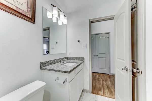 a en suite bathroom with a granite countertop sink and a mirror