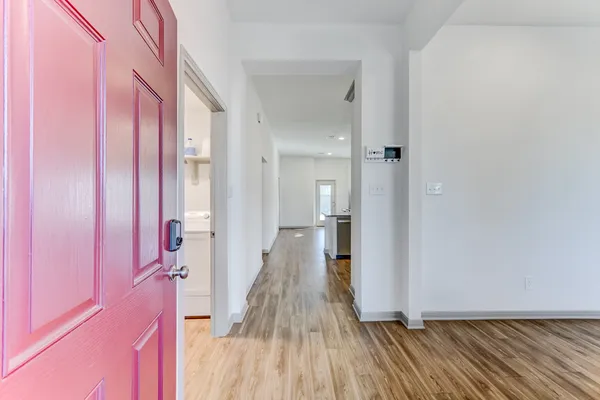 a view of a hallway with wooden floor and staircase