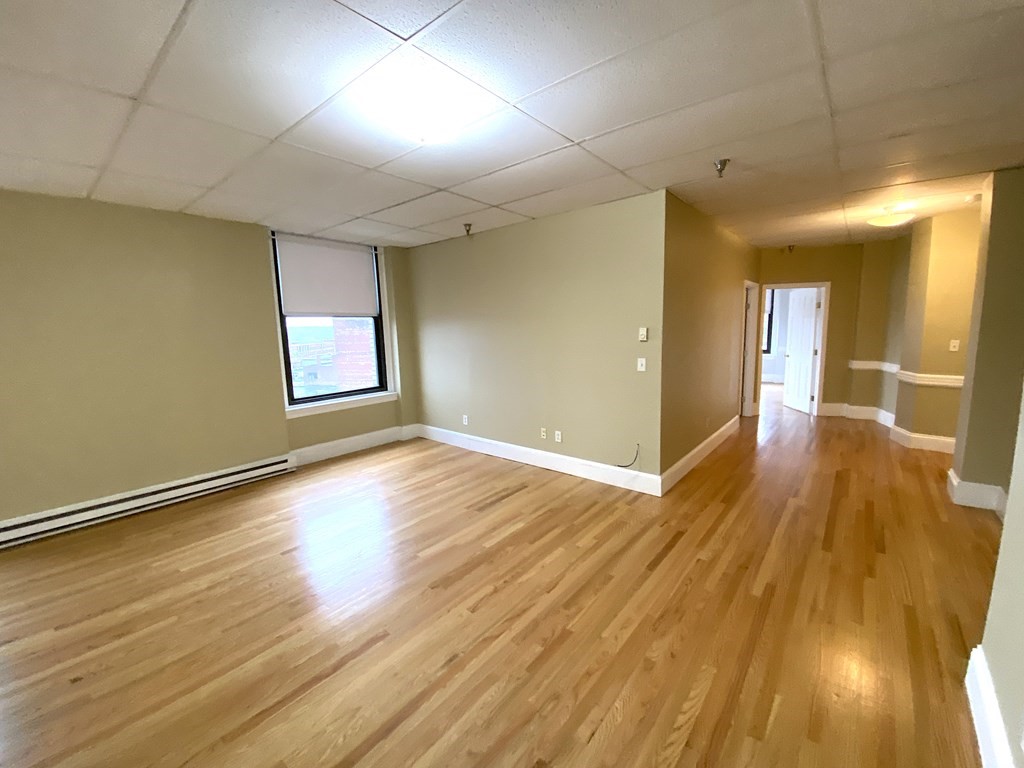 a view of a room with wooden floor and window