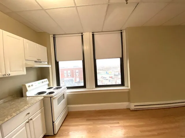a view of a kitchen with wooden floor and electronic appliances