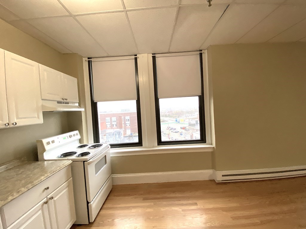 11 Lawrence Street, Unit 606 Lawrence, MA 01840 - Photo 5 of 10 a view of a kitchen with wooden floor and electronic appliances