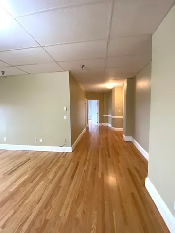 a view of empty room with wooden floor