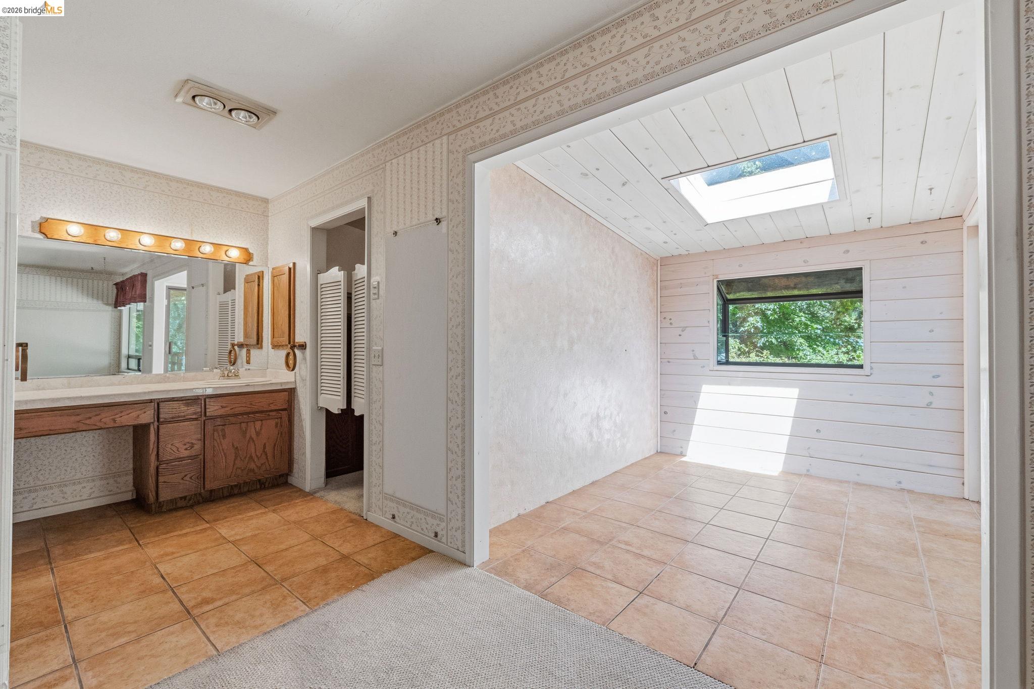 22401 South Fork Road Sonora, CA 95370 - Photo 24 of 34 Bathroom featuring a dual vanity with wood cabinetry and a light-toned countertop, complemented by a large mirror and overhead lighting