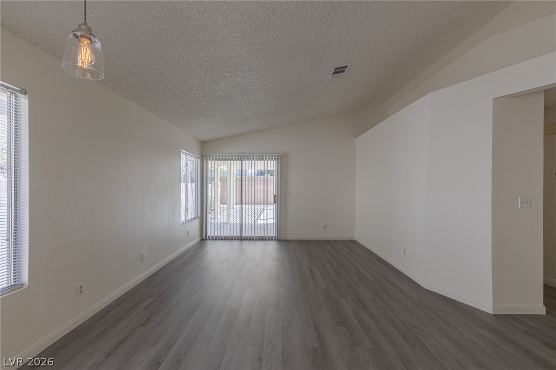 2803 Mirage Road Henderson, NV 89074 - Photo 8 of 39 Vaulted ceilings and wood-look flooring enhance this versatile living area opening to the patio.