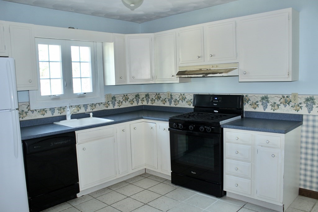 111 County Road East Freetown, MA 02717 - Photo 14 of 29 a kitchen with white cabinets and a stove
