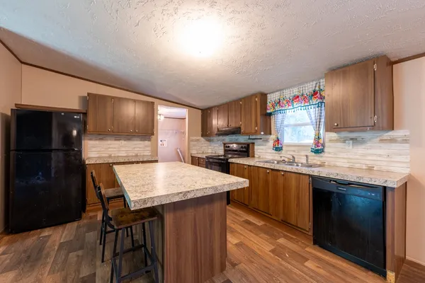 a kitchen with granite countertop a sink stove and refrigerator