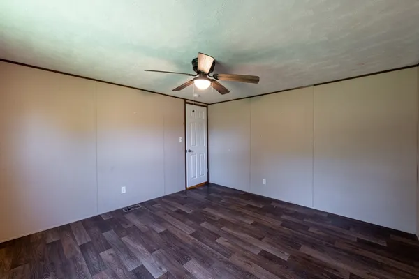 a view of wooden floor and chandelier fan in an empty room
