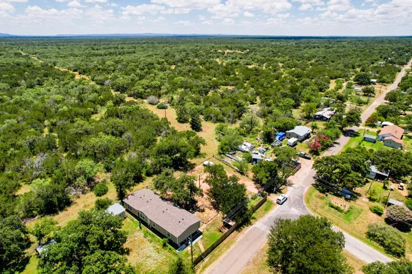 an aerial view of residential house with outdoor space and trees all around
