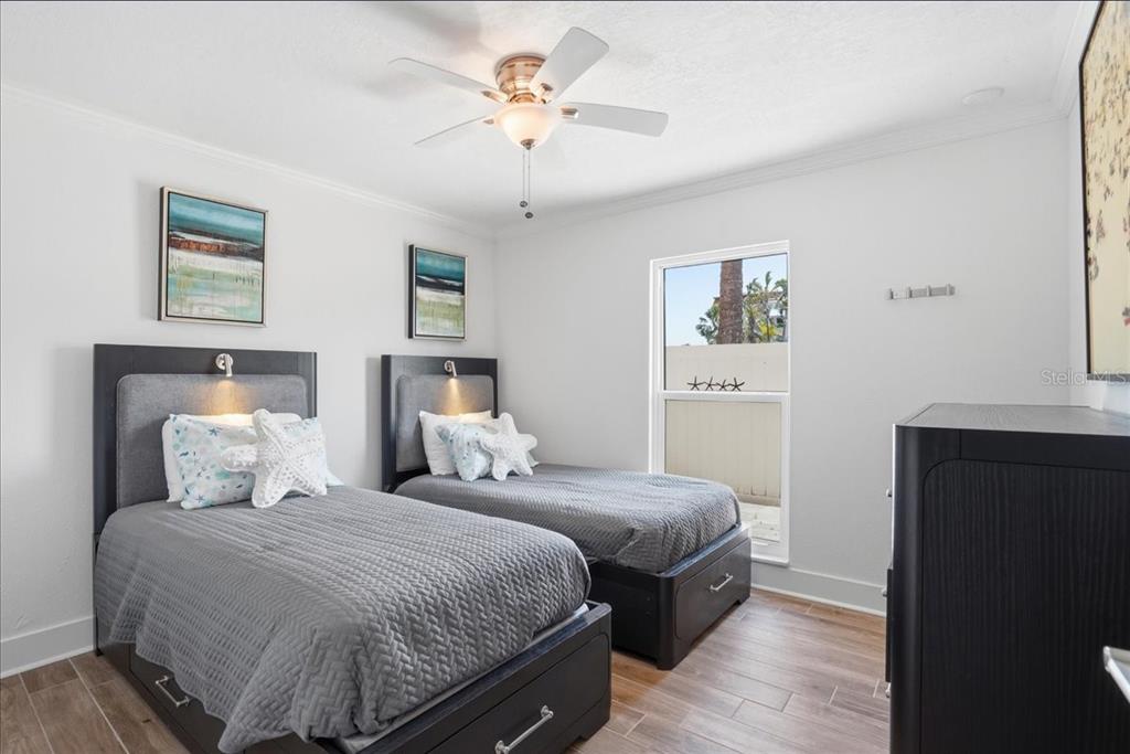 8911 Blind Pass Road, Unit 118 St. Pete Beach, FL 33706 - Photo 28 of 34 a bedroom with a bed and a chandelier