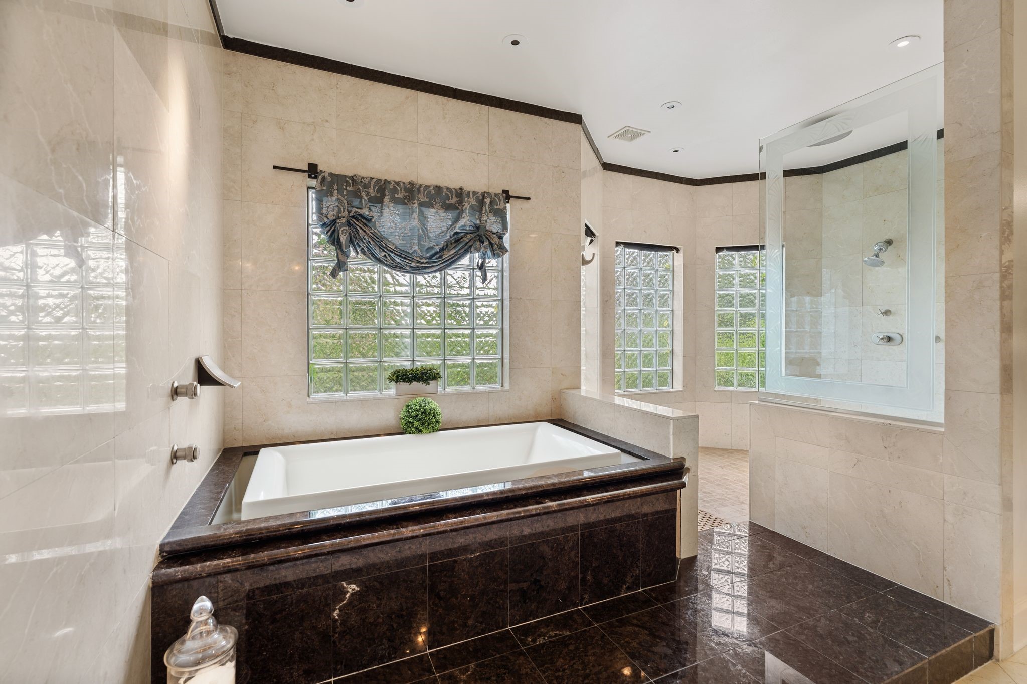 30 Hackberry Lane, Unit A Houston, TX 77027 - Photo 26 of 42 Infinity-edge jetted tub set in raised granite tile surround with marble tile backsplash