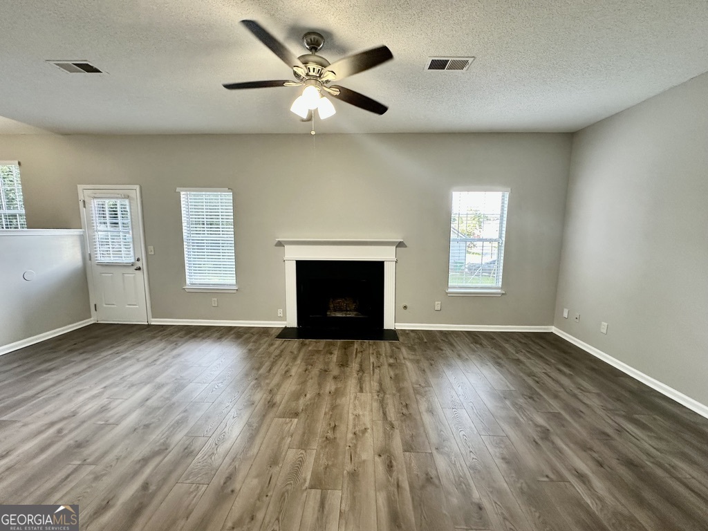 3763 Waldrop Hills Drive Decatur, GA 30034 - Photo 9 of 31 an empty room with wooden floor a ceiling fan and windows