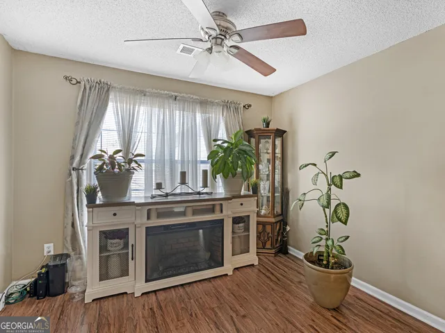 a kitchen with stainless steel appliances a stove and white cabinets with wooden floor
