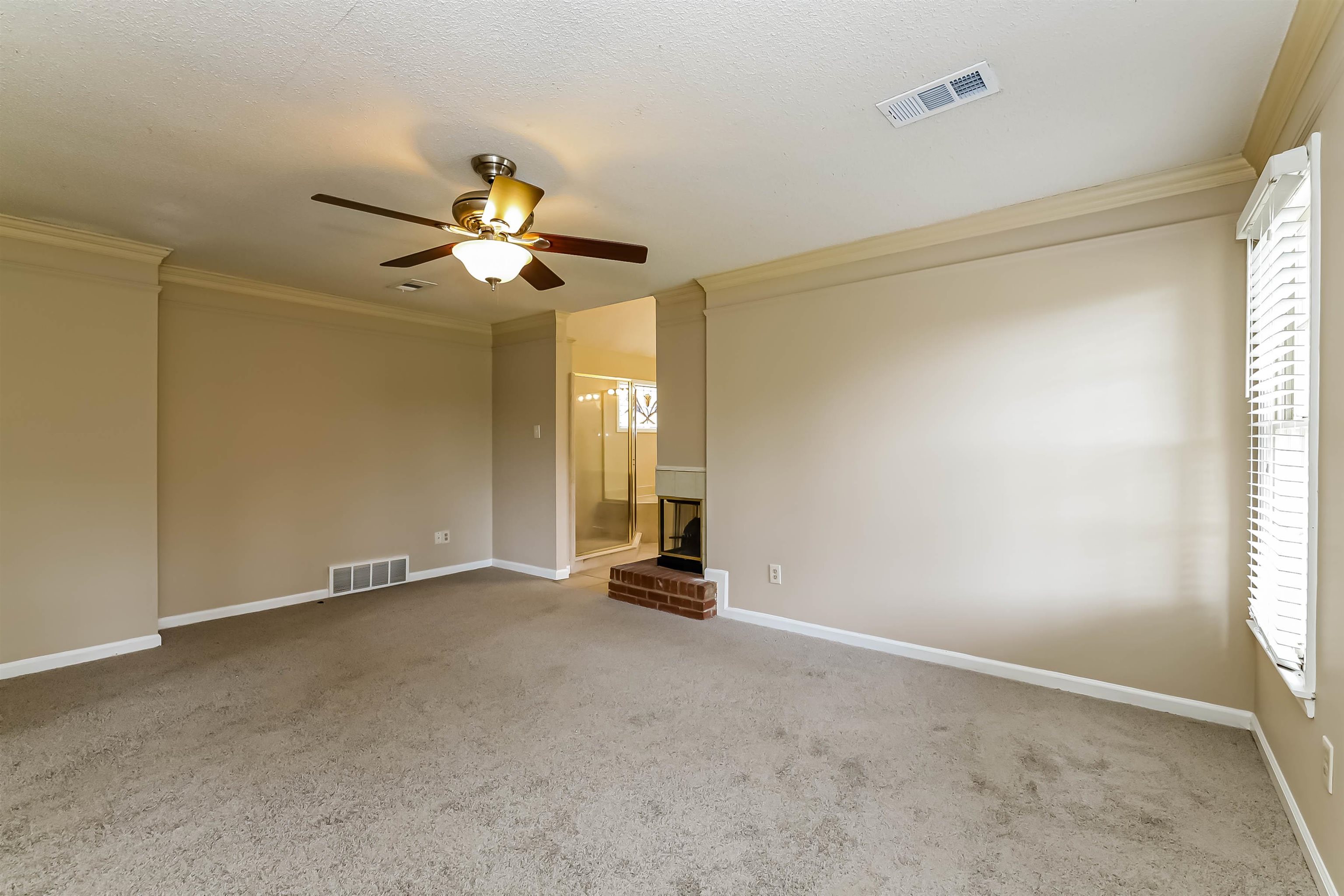432 Leaf Trail Lane Memphis, TN 38018 - Photo 10 of 17 Carpeted empty room with a fireplace, crown molding, and ceiling fan