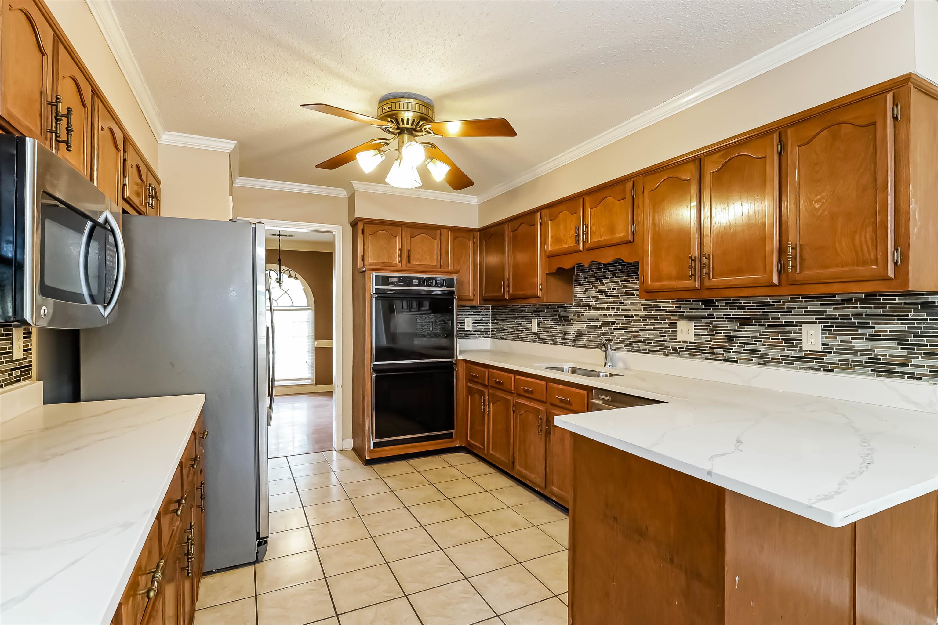432 Leaf Trail Lane Memphis, TN 38018 - Photo 7 of 17 Kitchen with sink, decorative backsplash, ceiling fan, and light stone counters