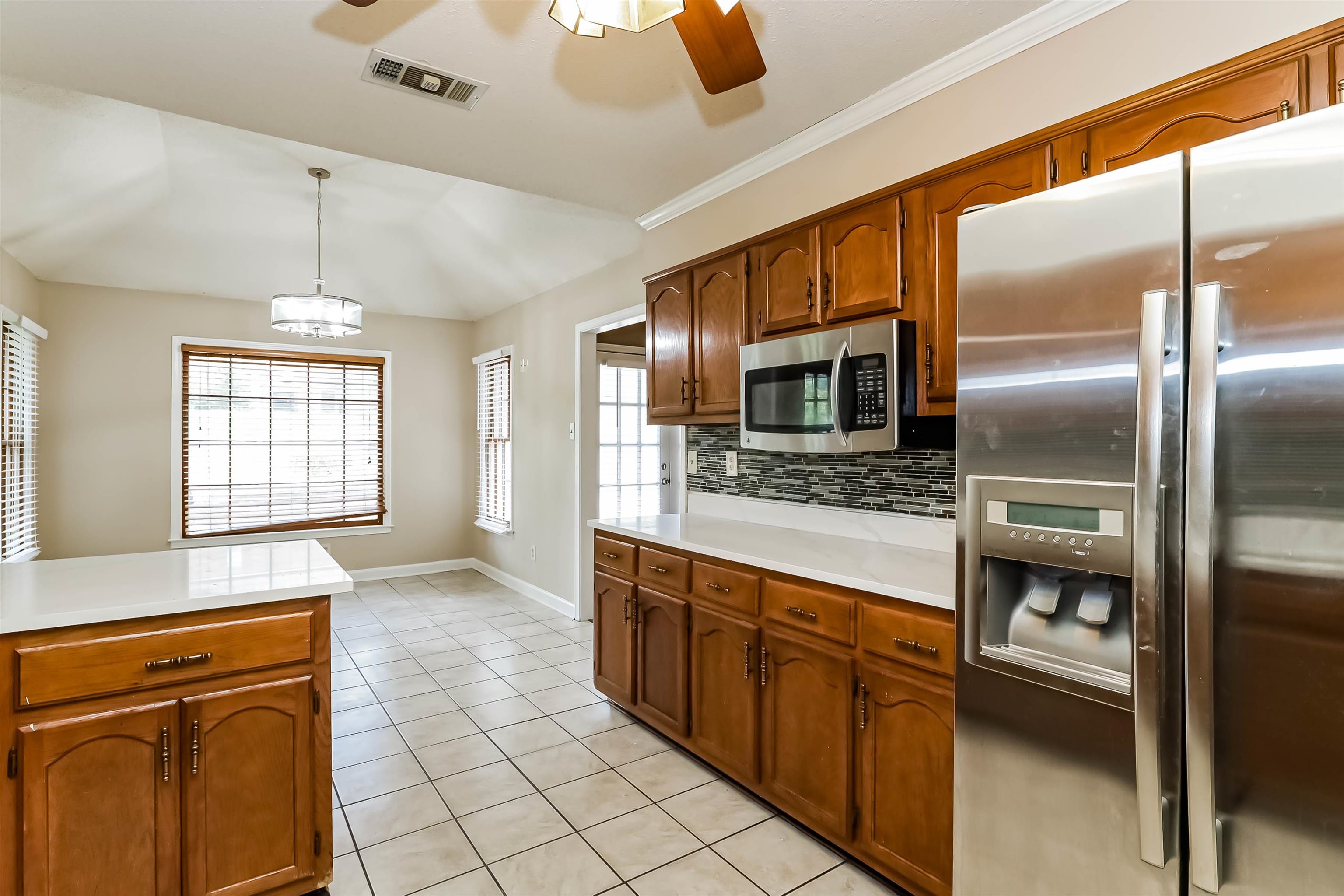 432 Leaf Trail Lane Memphis, TN 38018 - Photo 8 of 17 Kitchen with tasteful backsplash, stainless steel appliances, ceiling fan with notable chandelier, pendant lighting, and light tile patterned floors