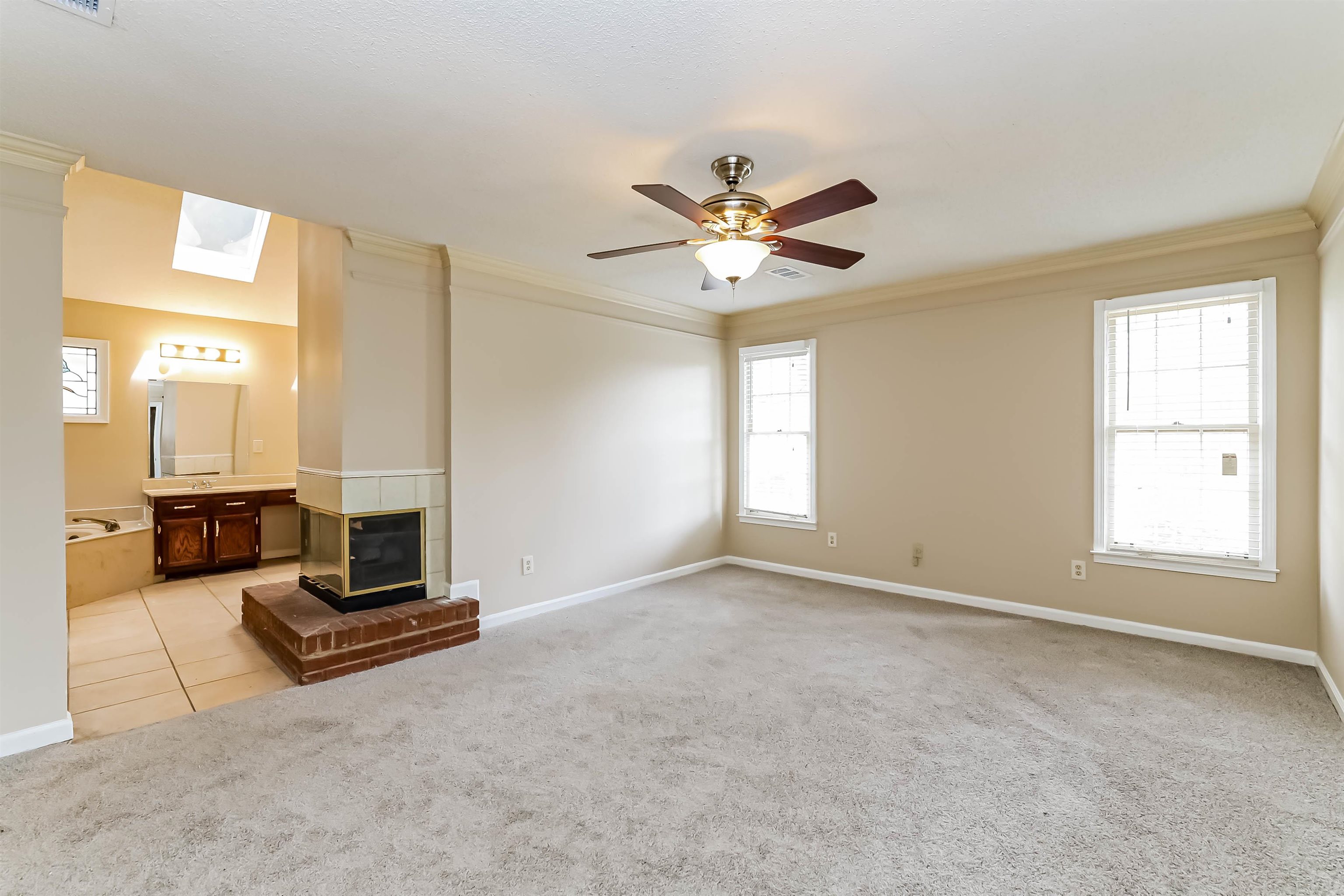 432 Leaf Trail Lane Memphis, TN 38018 - Photo 9 of 17 Carpeted living room featuring plenty of natural light, crown molding, ceiling fan, and a skylight