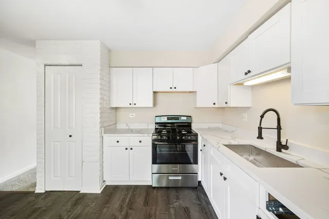 a kitchen with a sink stove and cabinets