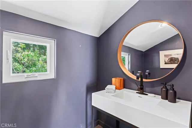 a bathroom with a sink a toilet and a mirror