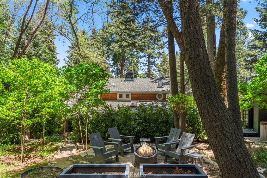 609 Millburn Road Lake Arrowhead, CA 92352 - Photo 52 of 60 a view of a patio with table and chairs and a large tree