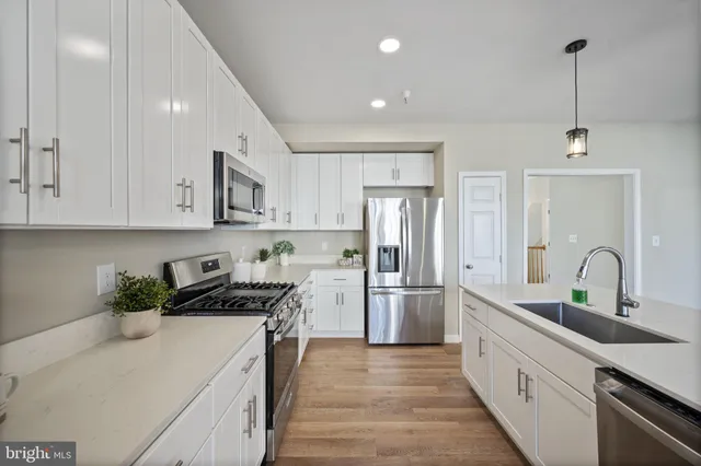 a kitchen with stainless steel appliances a sink stove and refrigerator
