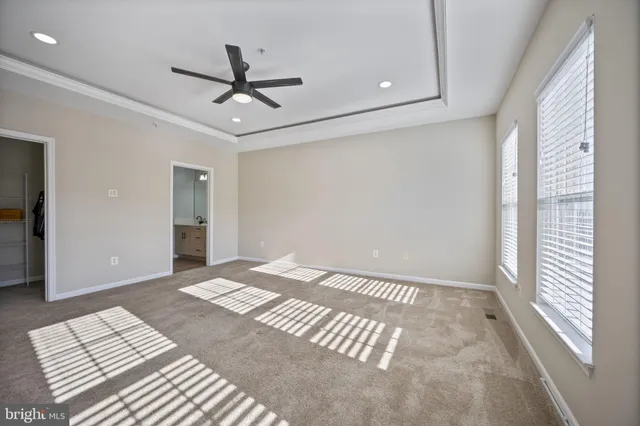 a view of a livingroom with a chandelier fan and wooden floor
