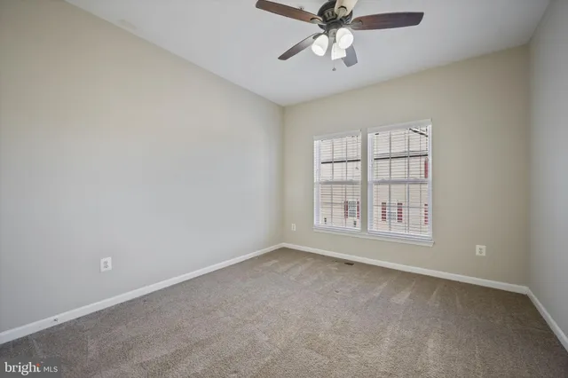 an empty room with chandelier fan
