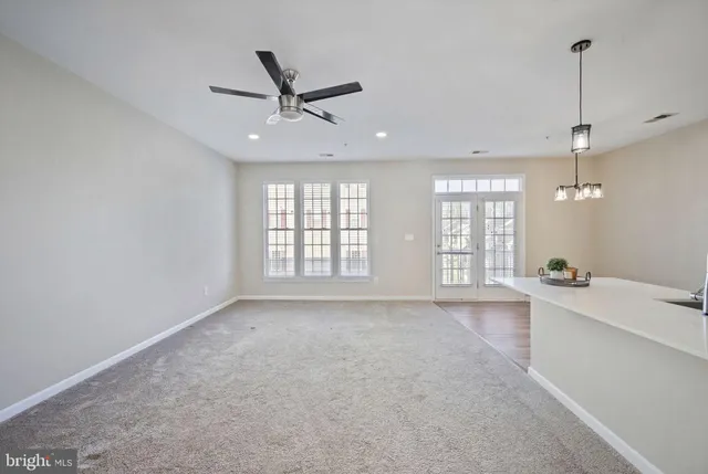 a kitchen with stainless steel appliances kitchen island granite countertop a stove a sink a refrigerator and white cabinets with wooden floor