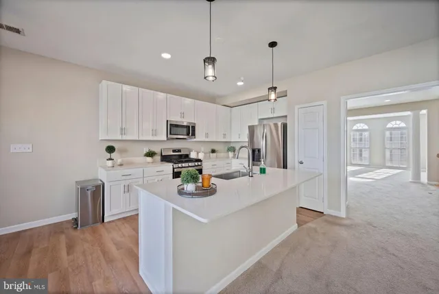 a kitchen with refrigerator a stove and white cabinets