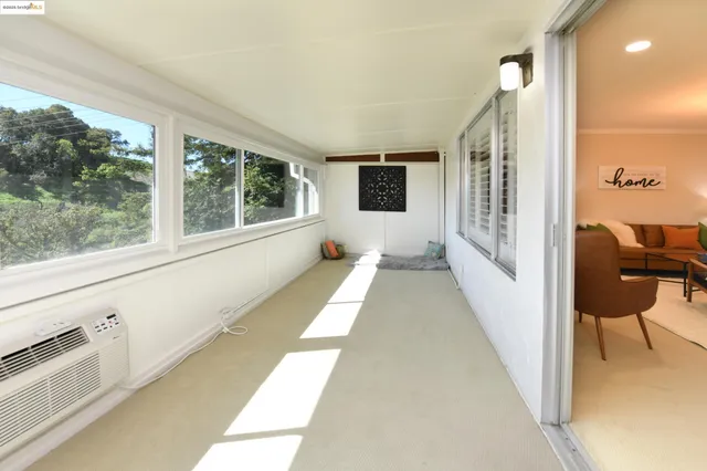 a view of a living room hardwood floor and a large window