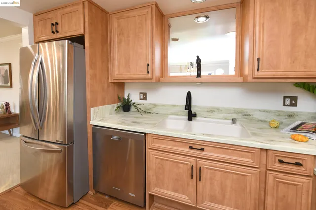 a kitchen with stainless steel appliances granite countertop a refrigerator and cabinets