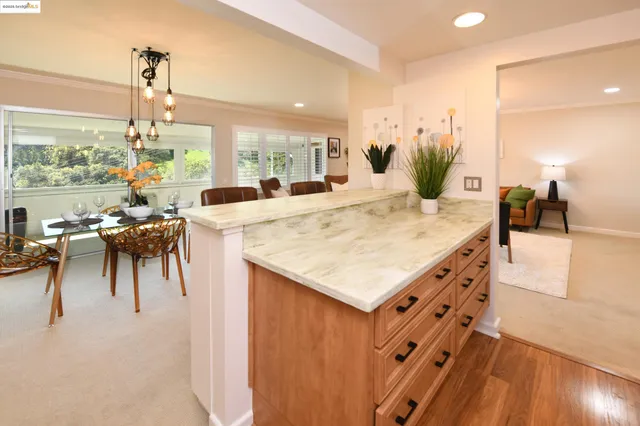 a kitchen with a table chairs and a view of living room