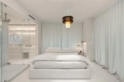 a spacious bedroom with a bed and a shower